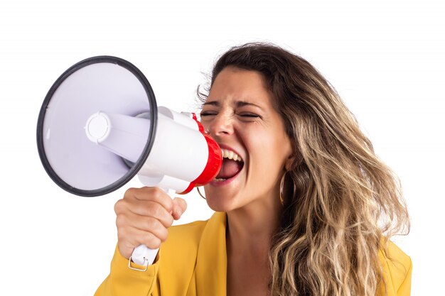 Ritratto di giovane bella donna che grida su un megafono isolato su bianco