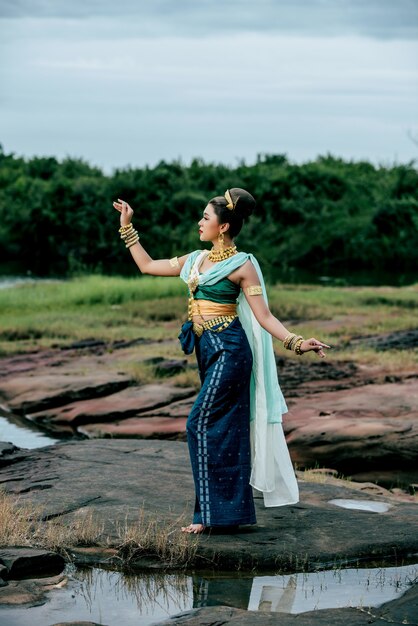 Ritratto di giovane bella donna che indossa in costume tradizionale con ornamento in posa nella natura in Thailandia