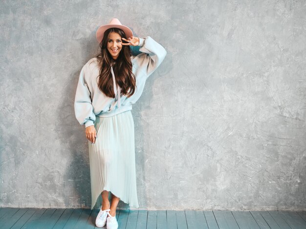 Ritratto di giovane bella donna sorridente alla ricerca. Ragazza alla moda in felpa estiva casual e abiti gonna.