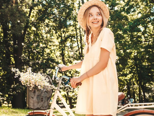 Ritratto di giovane bella ragazza sorridente hipster in prendisole estive alla moda