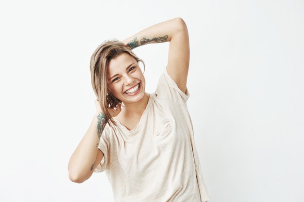 Ritratto di giovane bella ragazza tatuata in posa sorridente.