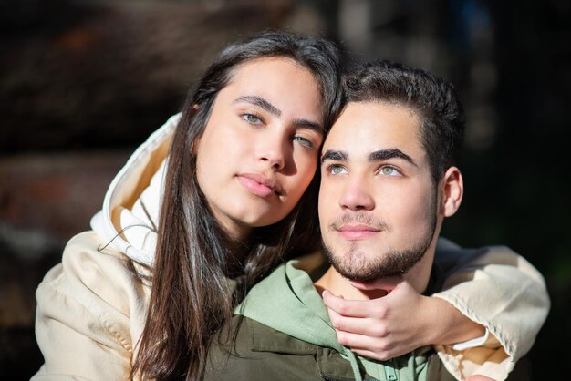 Ritratto di giovane coppia affettuosa che si abbraccia nella foresta. Donna con capelli scuri che abbraccia uomo barbuto sulle spalle. Amore, affetto, concetto di relazione