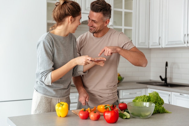 Ritratto di giovane coppia amorosa che cucina insieme insalata