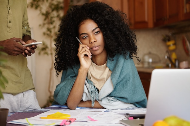 Ritratto di giovane donna africana con acconciatura afro rispondendo alla chiamata dalla banca