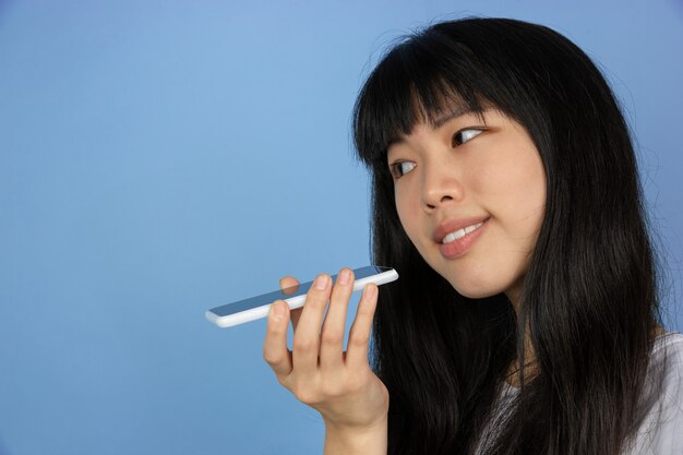 Ritratto di giovane donna asiatica isolata sullo spazio blu dello studio
