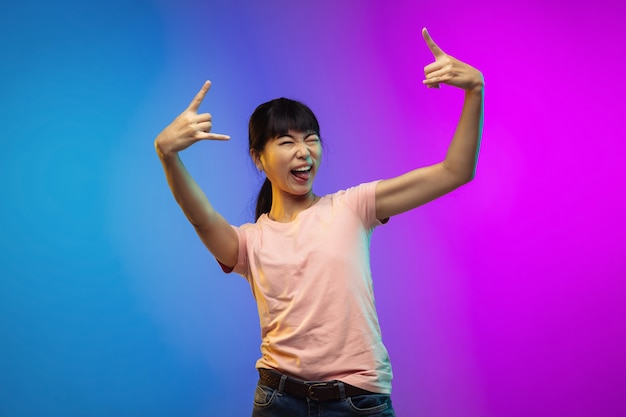Ritratto di giovane donna asiatica su gradiente in neon