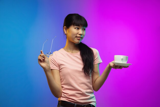 Ritratto di giovane donna asiatica su studio sfumato in neon