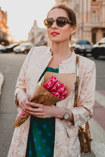 Ritratto di giovane donna attraente alla moda che cammina in città