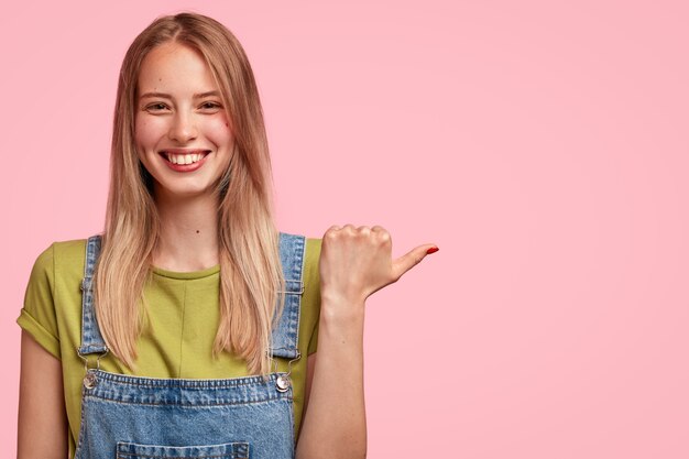 Ritratto di giovane donna bionda che indossa una tuta in denim