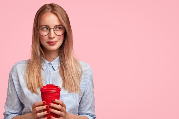 Ritratto di giovane donna bionda che tiene tazza di caffè