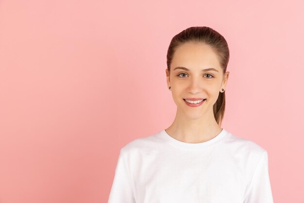 Ritratto di giovane donna caucasica isolato su sfondo rosa studio con copyspace