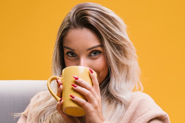 Ritratto di giovane donna che beve il caffè a casa