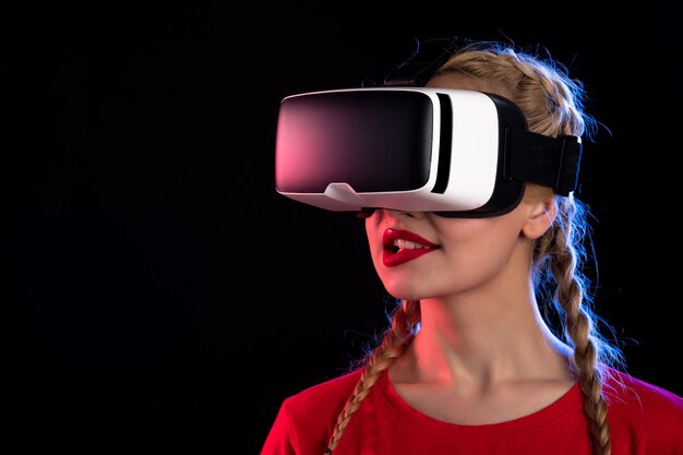 Ritratto di giovane donna che gioca con la realtà virtuale sul muro scuro