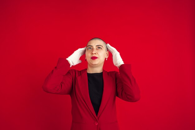 Ritratto di giovane donna con aspetto bizzarro sulla parete rossa
