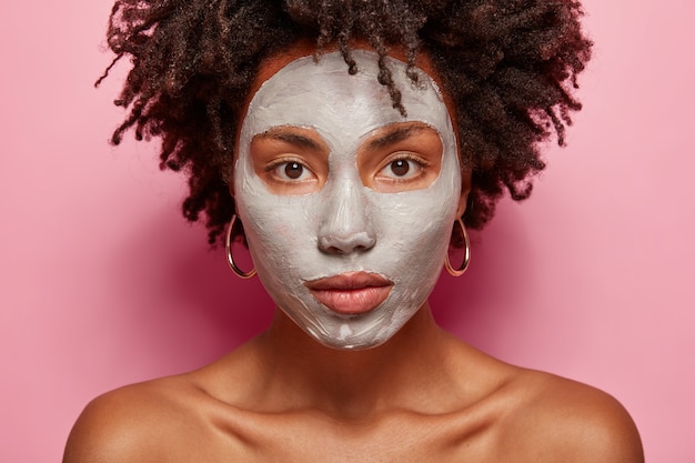 Ritratto di giovane donna con taglio di capelli afro e maschera per il viso