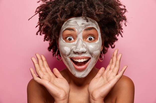 Ritratto di giovane donna con taglio di capelli afro e maschera per il viso