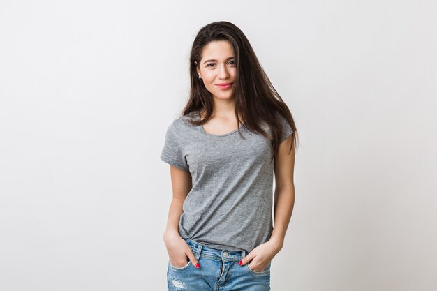 Ritratto di giovane donna graziosa alla moda sorridente in maglietta grigia su, isolato, aspetto naturale, lunghi capelli castani, jeans, sexy, stile casual