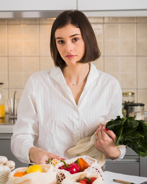 Ritratto di giovane donna in posa con verdure biologiche