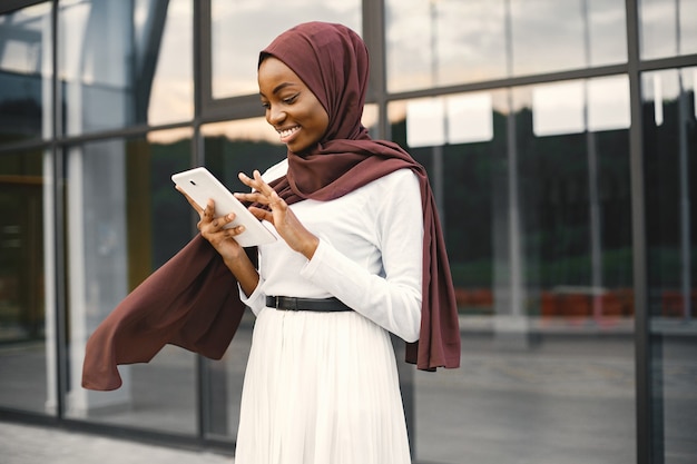 Ritratto di giovane donna musulmana che indossa l'hijab utilizzando un tablet