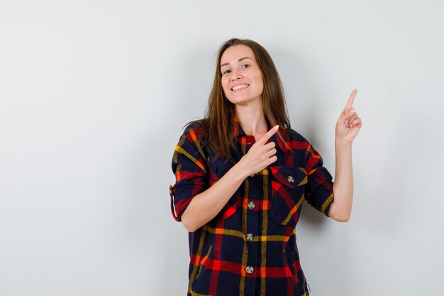 Ritratto di giovane donna rivolta verso l'alto in camicia casual e guardando felice vista frontale