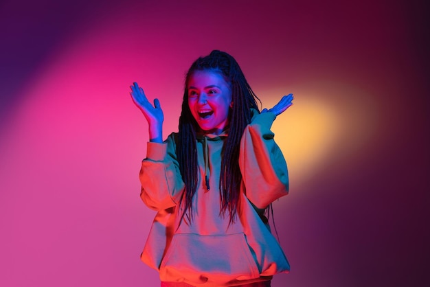 Ritratto di giovane donna su sfondo di studio di colori sfumati al neon Concetto di emozioni umane