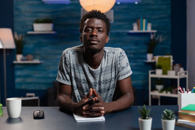 Ritratto di giovane impiegato afroamericano che ha riunione di videochiamata online