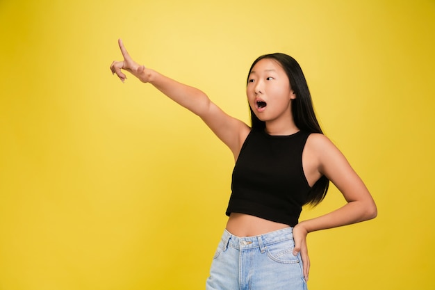 Ritratto di giovane ragazza asiatica isolata sul muro giallo