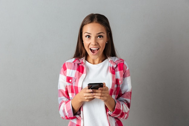 Ritratto di giovane ragazza felice, messaggio SMS sui telefoni
