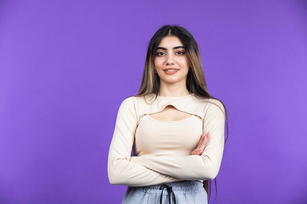 Ritratto di giovane ragazza sicura di sé incrociò le braccia e guardando la telecamera