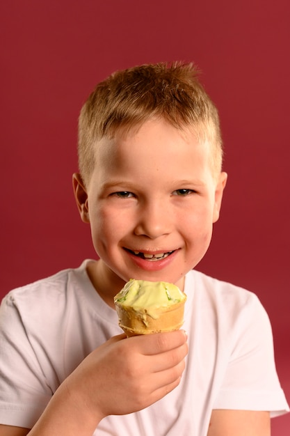 Ritratto di giovane ragazzo sveglio che mangia il gelato