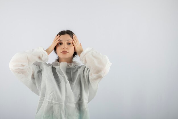 Ritratto di giovane scienziato medico femminile nella posa difensiva del camice da laboratorio.