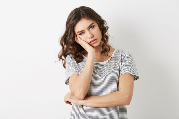 Ritratto di giovane signora stanca che ha un problema, frustrato, stress, triste emozione, isolato, guardando a porte chiuse, semplice t-shirt