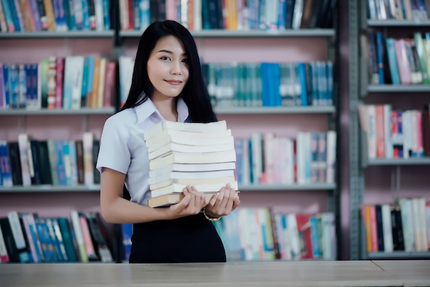 Ritratto di giovane studente che legge un libro in una biblioteca