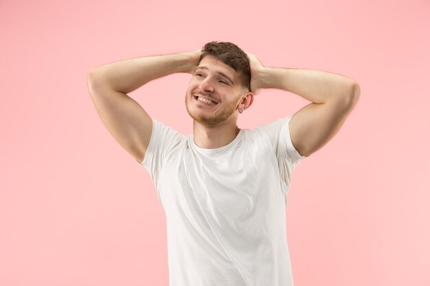 Ritratto di giovane uomo alla moda su sfondo rosa. Espressione emotiva.