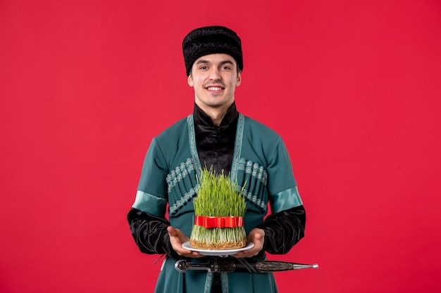 Ritratto di giovane uomo azero in costume tradizionale con semeni su red