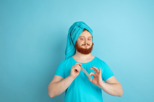 Ritratto di giovane uomo caucasico nella sua giornata di bellezza e routine di cura della pelle.