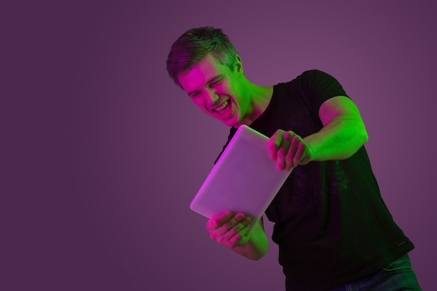Ritratto di giovane uomo che gioca con il tablet con luci al neon