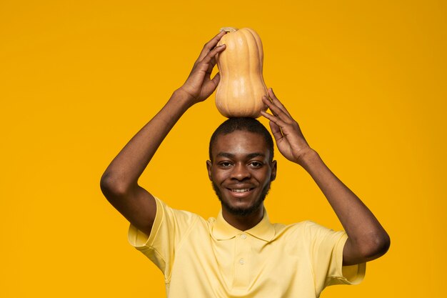 Ritratto di giovane uomo che tiene la zucca sulla sua testa