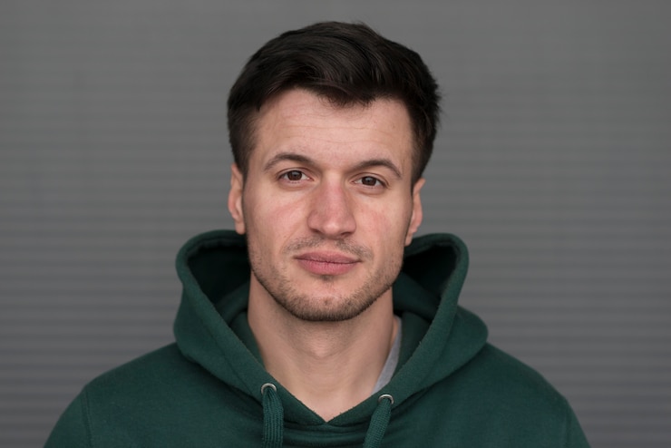 Foto gratuito ritratto di giovane uomo con felpa verde