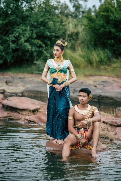 Ritratto di giovane uomo e donna che indossa un bellissimo costume tradizionale posa in natura in Thailandia