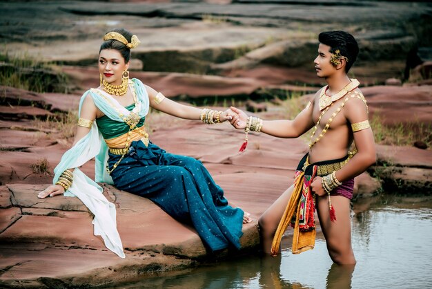 Ritratto di giovane uomo e donna che indossa un bellissimo costume tradizionale posa in natura in Thailandia