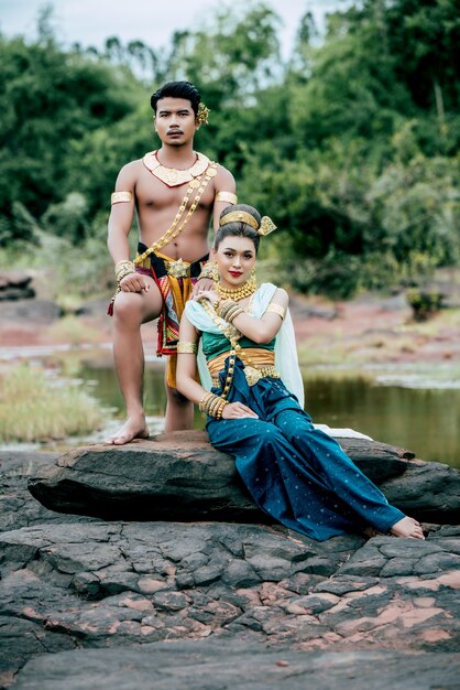 Ritratto di giovane uomo e donna che indossa un bellissimo costume tradizionale posa in natura in Thailandia