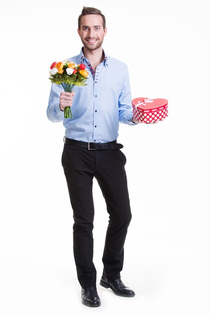 Ritratto di giovane uomo felice con fiori e un regalo - isolato su bianco.