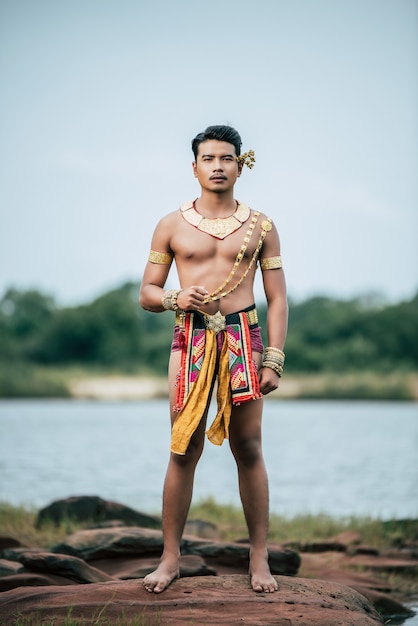 Ritratto di giovane uomo in costume tradizionale in posa in natura in Thailandia