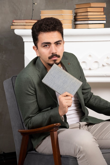 Ritratto di giovane uomo in posa con il suo libro.