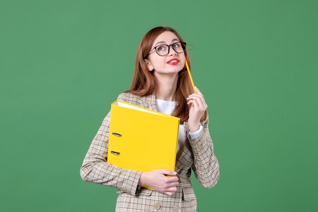 Ritratto di insegnante femminile con file gialli su verde