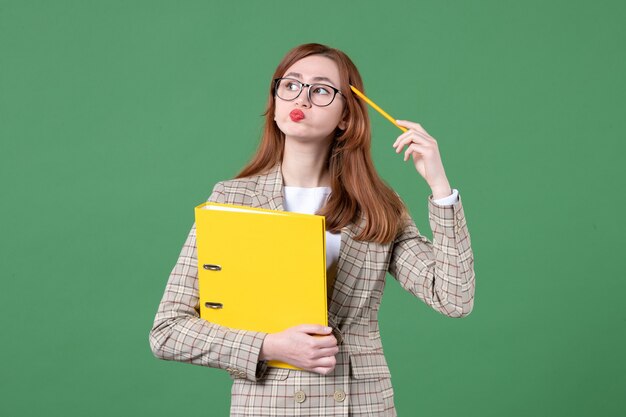 Ritratto di insegnante femminile con file gialli su verde