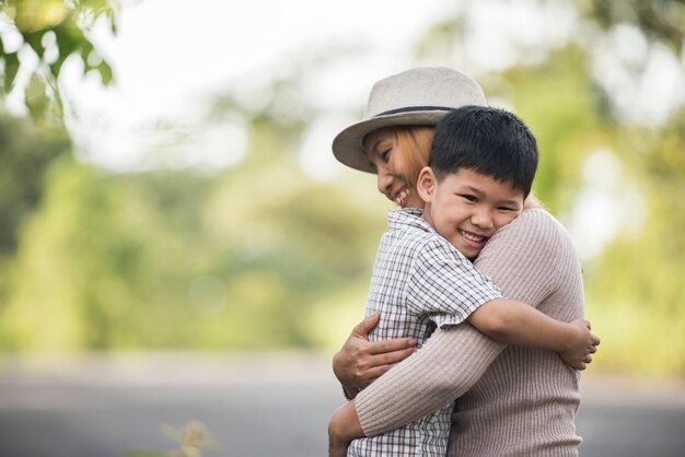 Ritratto di madre e figlio felice abbraccio insieme nel parco. Concetto di famiglia