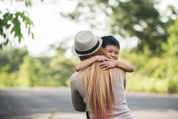 Ritratto di madre e figlio felice abbraccio insieme nel parco. Concetto di famiglia