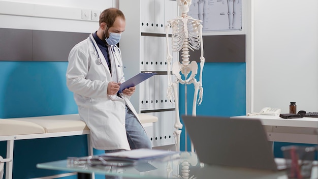 Ritratto di medico generico con camice bianco e stetoscopio sorridente davanti alla telecamera. Medico maschio con esperienza medica e preparazione per l'appuntamento di controllo sanitario.